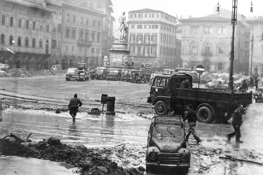 A black and white image showing the aftermath of a flooding in a Florence square.