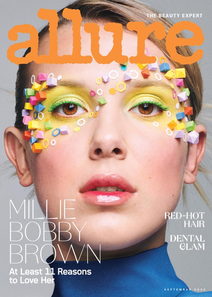 Millie Bobby Brown on the cover of Allure magazine. The close-up portrait features Brown with her hair slicked back wearing bright yellow and green eye shadow and a glossy lip. Small shapes made of colorful paper have been glued in a swirling pattern that outlines her eyes. 