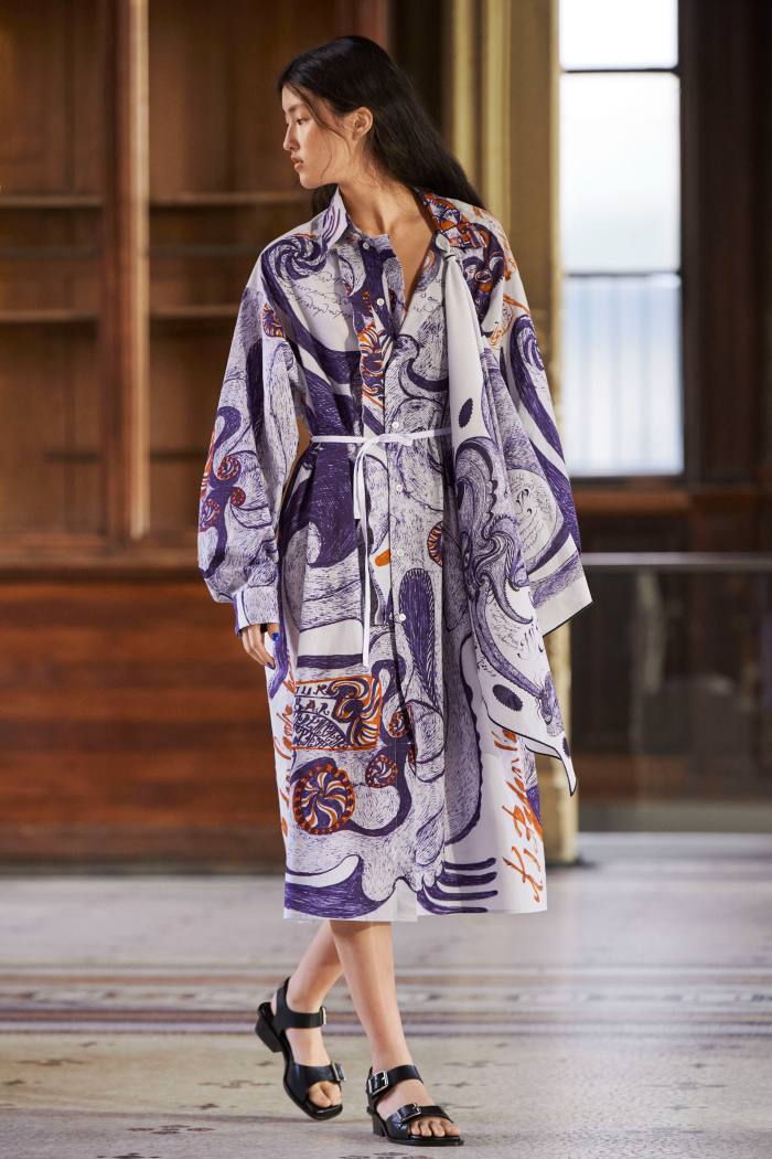 A model wears a predominantly purle-printed white kimono and flat sandals