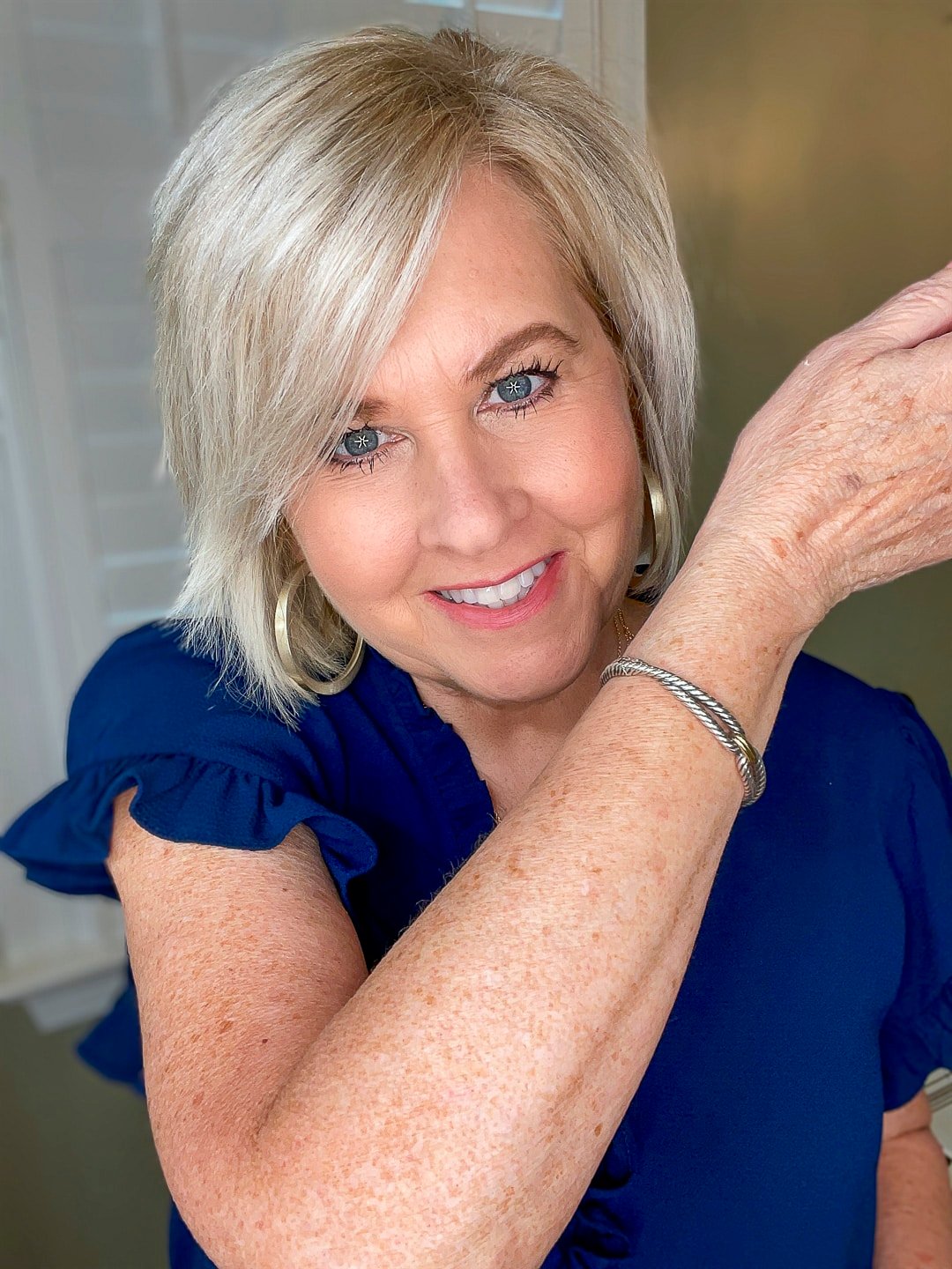 Over 40 Fashion Blogger, Tania Stephens is wearing a blue top and trying City Beauty's Inviscrepe Body Balm 7